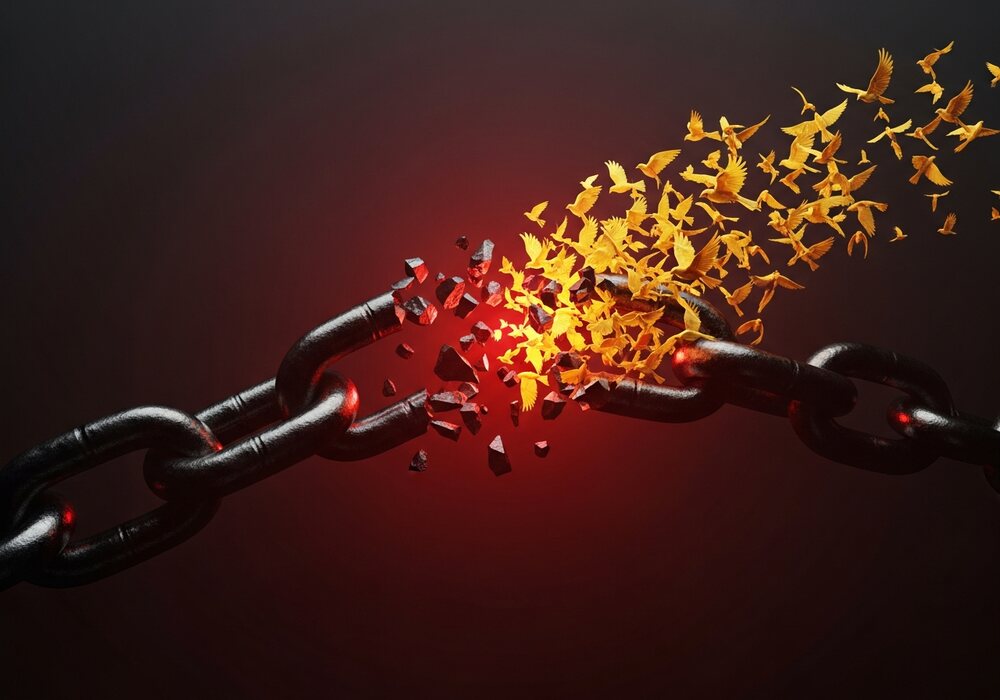 A breaking chain releasing golden birds — liberation and financial freedom